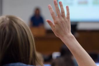 Student raising their hand in a presentation