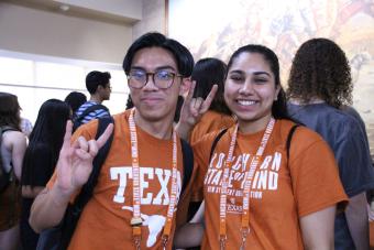students posing together with a hookem horns