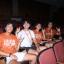 Students sitting in an auditorium doing Hookem Horns Sign